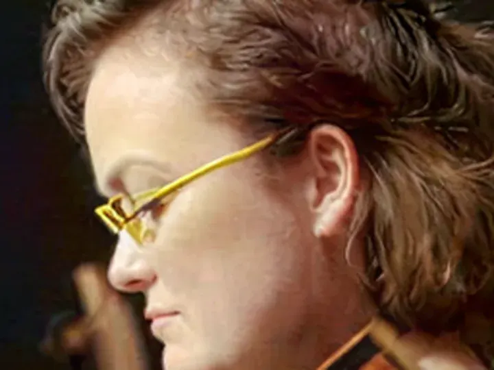 Crystal: a musician with thin wire glasses, heavy JPEG